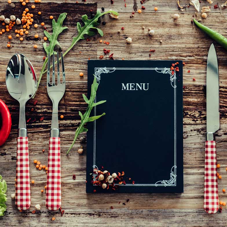 Menu and silverware on wooden table